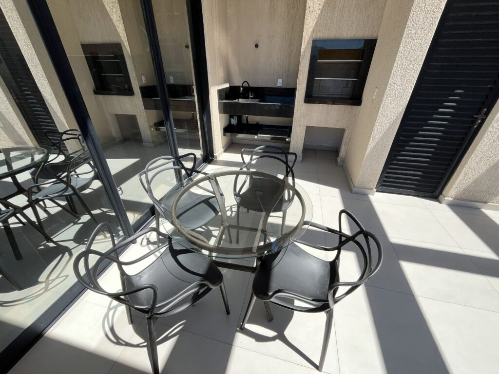 Área gourmet - churrasqueira e mesa de vidro